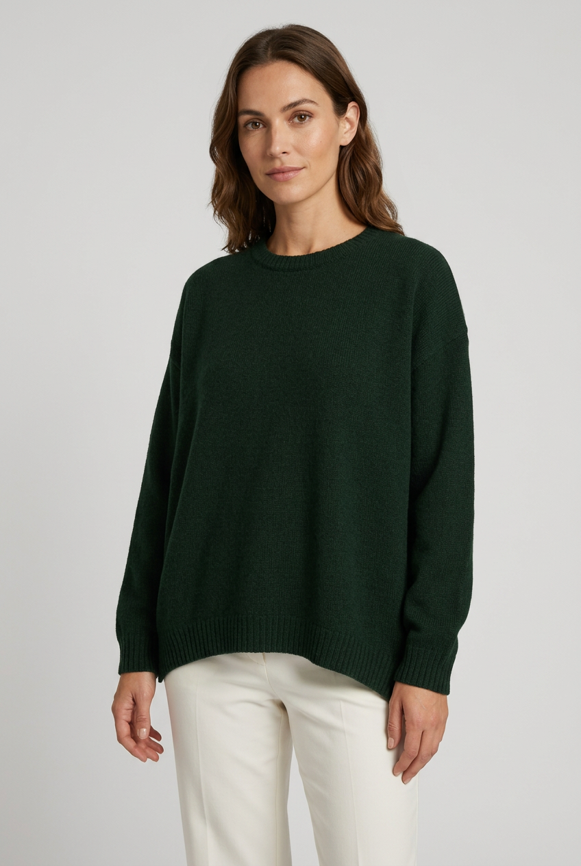 Camisola de lã oversized verde-escura vestida por modelo com calças claras