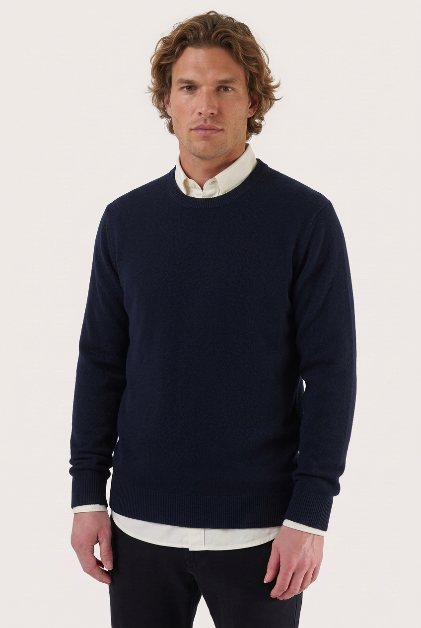 Camisola de lã e caxemira azul-escura com decote redondo, modelo com camisa branca