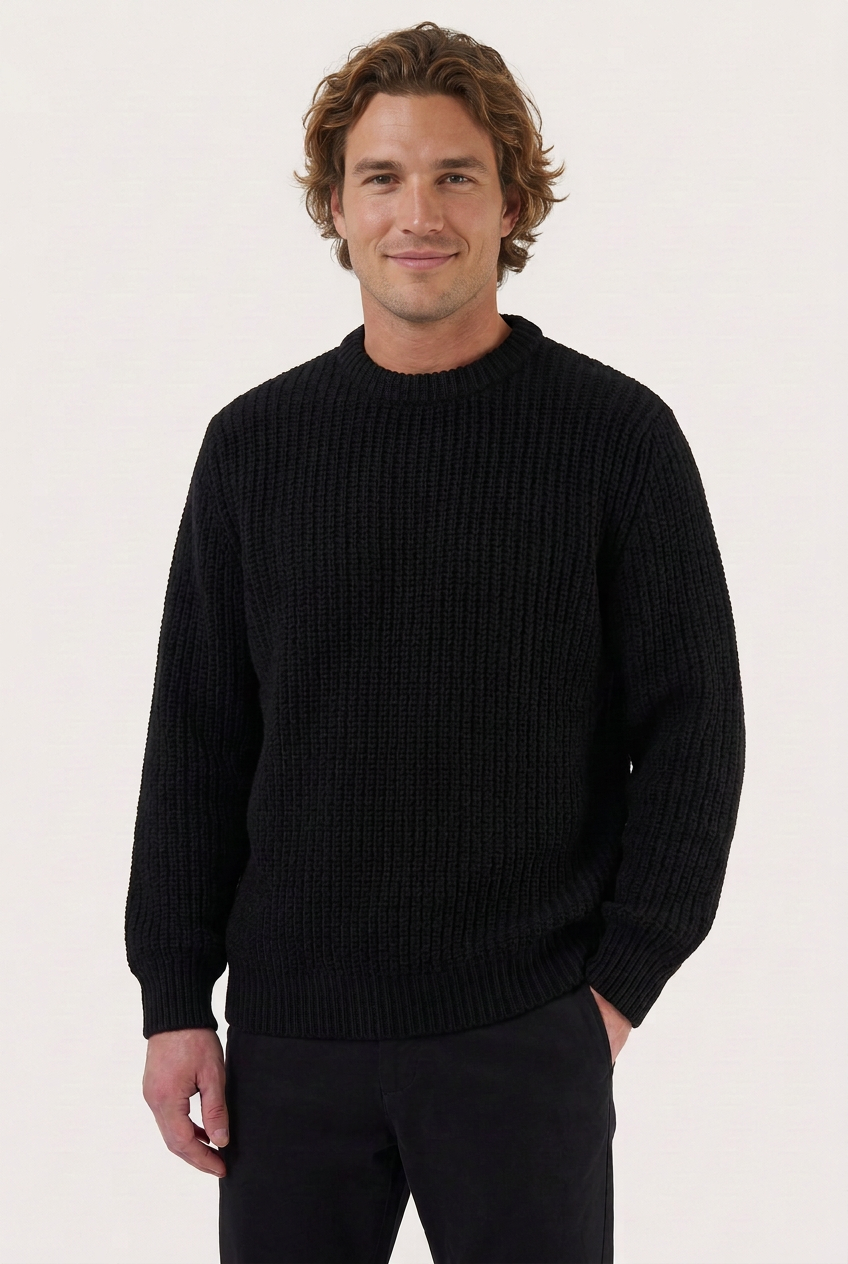Camisola de lã chunky preta vestida por modelo masculino com sorriso discreto e expressão alegre